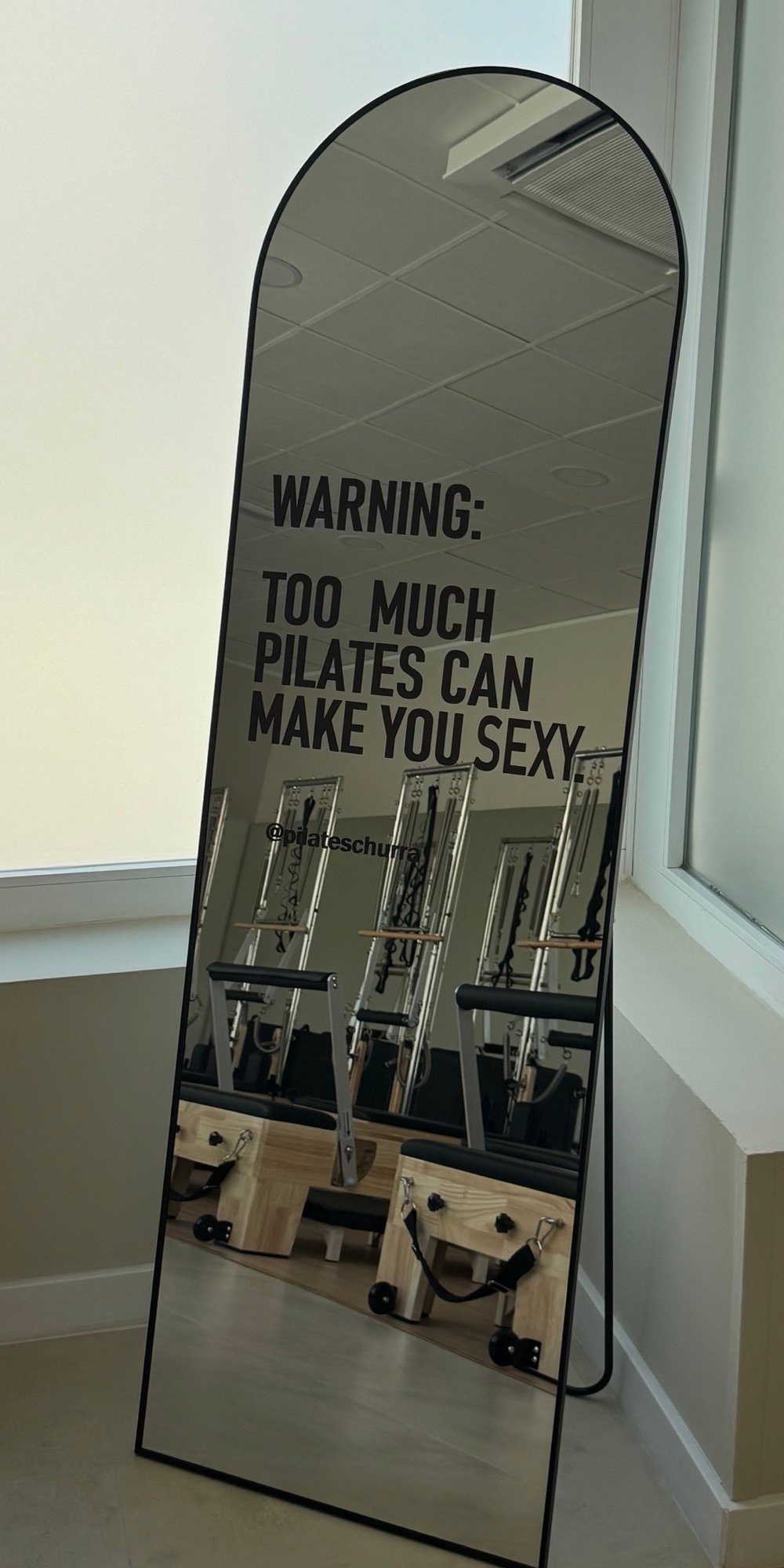 Espejo del studio Pilates Churra con los reformers al fondo